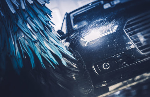 a black car getting automatic car wash - Spark